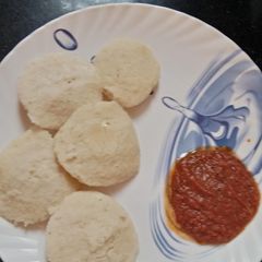 A picture of Idli with tomato chutney.