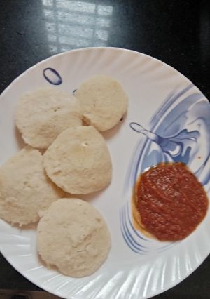 A picture of Idli with tomato chutney.
