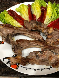 Una foto de Chuletas de cordero con cogollos de Tudela y pimientos asados
