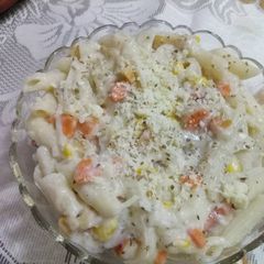 A picture of Cheesy penne pasta in white creamy sauce.