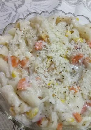 A picture of Cheesy penne pasta in white creamy sauce.