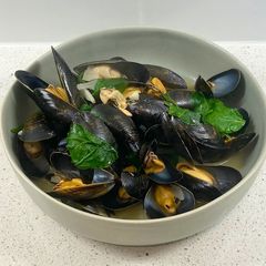 A picture of Mussels in a white wine, butter, garlic and parsley sauce.