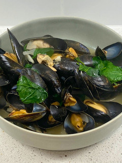 A picture of Mussels in a white wine, butter, garlic and parsley sauce.