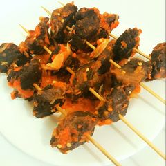 A picture of Peppered fried beef on skewer.