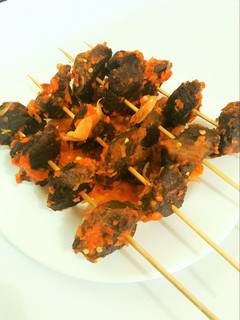 A picture of Peppered fried beef on skewer.