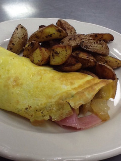 A picture of One egg omelette with home fries for one.