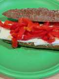 Sandwich with 7-Grain Bread, Brie Cheese, Roasted Red Pepper Strips, and Hummus