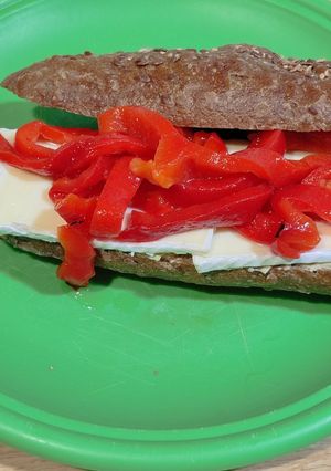 A picture of Sandwich with 7-Grain Bread, Brie Cheese, Roasted Red Pepper Strips, and Hummus.