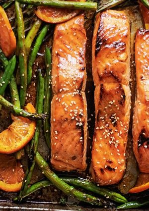 Una foto de Salmón glaseado con miel y soya con espárragos y naranja