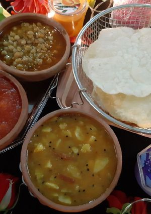 A picture of Aloo ki takari, choley ka salan, suji ka halwa and puri.