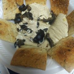 A picture of Hummus with Olives.
