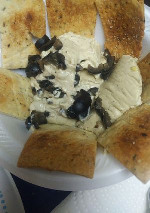 A picture of Hummus with Olives.