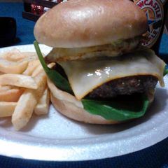 A picture of Chipotle Bacon cheeseburger topped with avocado and a fried egg.