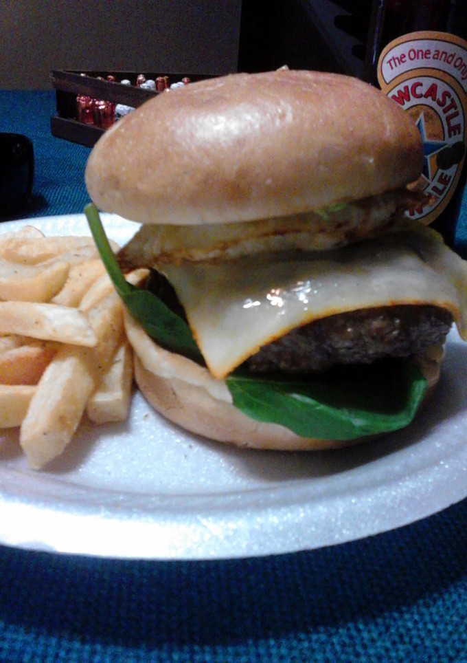 A picture of Chipotle Bacon cheeseburger topped with avocado and a fried egg.