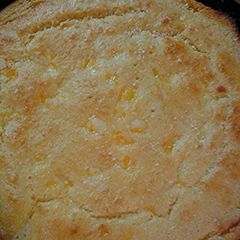 A picture of Cheesy cornbread in a cast iron pan.