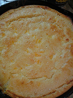 A picture of Cheesy cornbread in a cast iron pan.