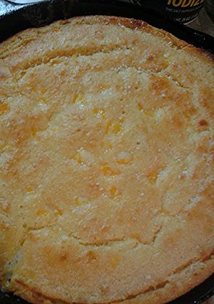 A picture of Cheesy cornbread in a cast iron pan.