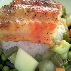 A picture of Broiled white fish over rice and vegetables.