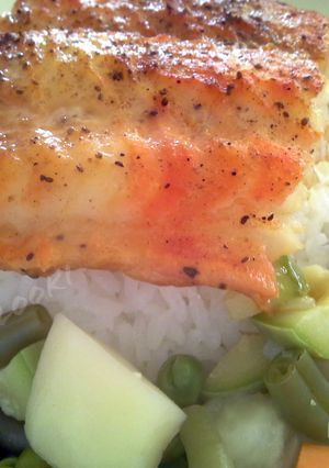 A picture of Broiled white fish over rice and vegetables.
