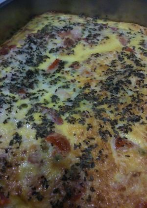 A picture of Omelette, with peas, tomatoes and ham.