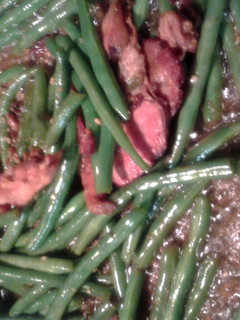 A picture of green beans fried with bacon and garlic.