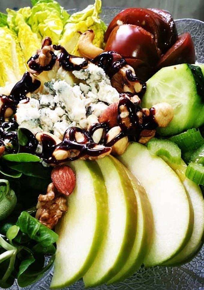 Una foto de Ensalada verde con alegría de tomate y frutos secos