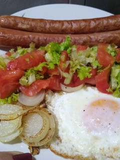 Una foto de Panchos con ensalada, cebolla y huevo frito. En minutos.