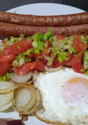 Una foto de Panchos con ensalada, cebolla y huevo frito. En minutos.