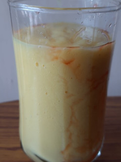 A picture of Mango shake with strawberry syrup.