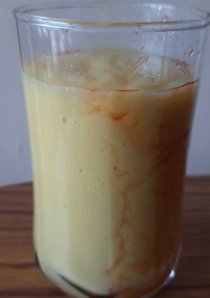 A picture of Mango shake with strawberry syrup.