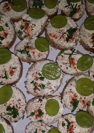 A picture of Bruschette with cheese and grapes.