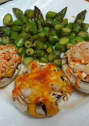 Una foto de Champiñones con surimi, gambas y cheddar con espárragos al ajillo