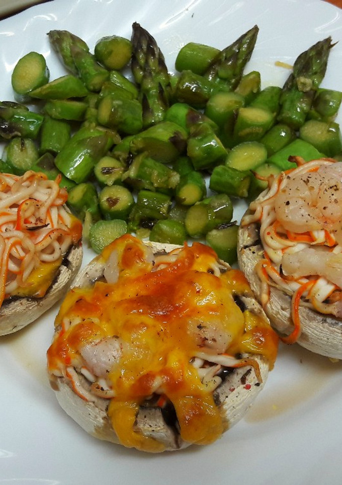 Una foto de Champiñones con surimi, gambas y cheddar con espárragos al ajillo