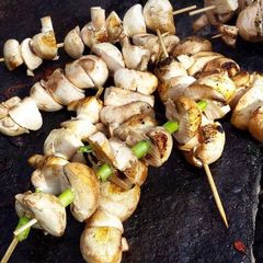 A picture of Grilled mushrooms on a stick.
