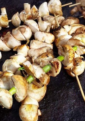 A picture of Grilled mushrooms on a stick.