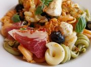 Una foto de ensalada con jamón serrano y fruta
