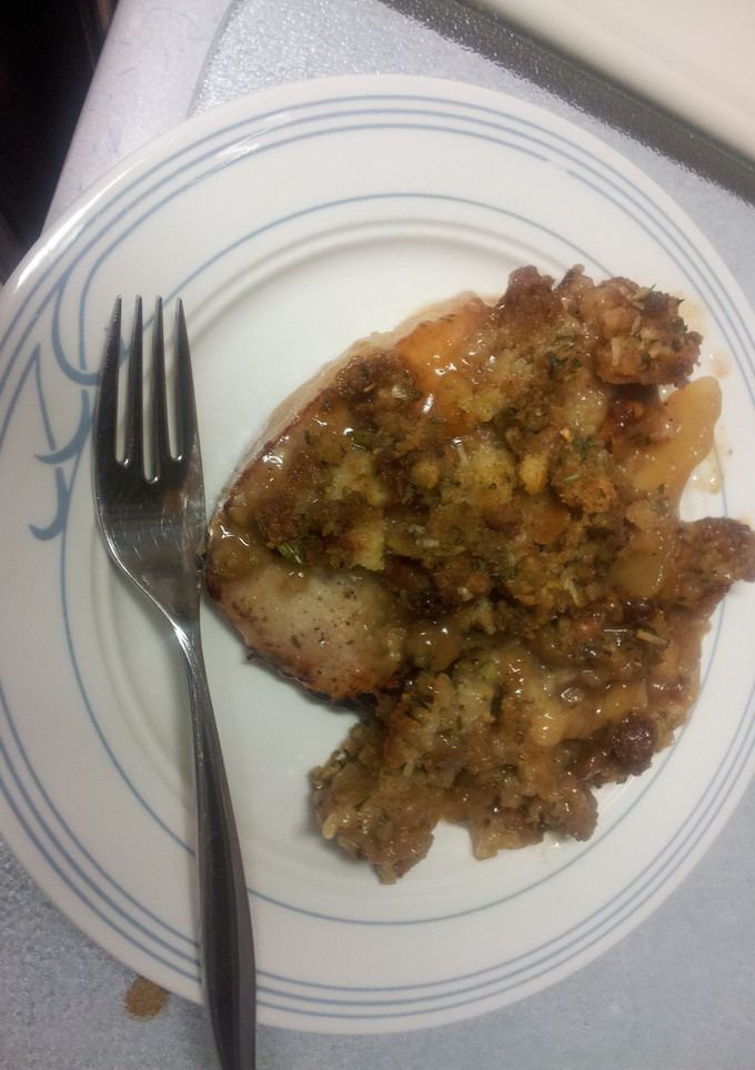 A picture of Pork chops with apples and stuffing.