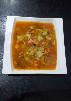 Une photo de Bouillon aromatique aux ravioles, saumon et crevettes