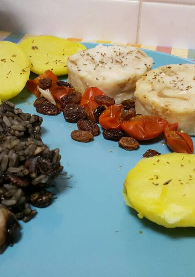 Una foto de Arroz negro con medallones de merluza y patata