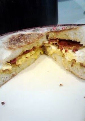A picture of cheesy egg proscutti breakfast sandwhich.