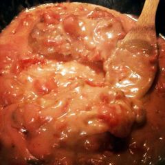 A picture of turkey breast in tomato gravy.