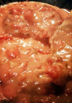 A picture of turkey breast in tomato gravy.