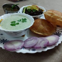 Kale chane, bathua ka raita with poori A picture of Kale chane, bathua ka raita with poori.