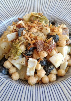 Una foto de Ensalada de patata y garbanzos con tomate seco, huevo y olivas negras al pesto