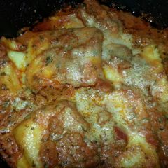 A picture of Ravioli with tomato pesto sauce.