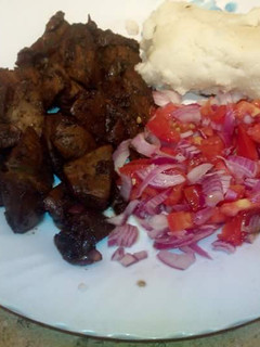 A picture of Deep fried pork with Kachumbari and Ugali.