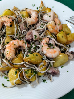 Una foto de Salteado de patatas con calamar, langostinos y gulas al ajillo