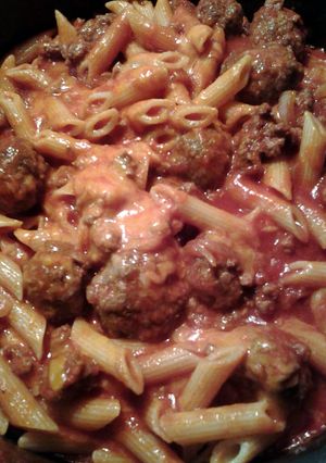 A picture of cheesy penne with mozzarella meatballs.