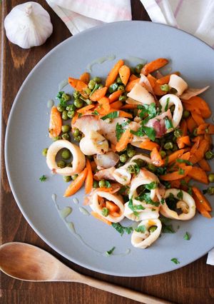 Foto di Anelli di calamari con carote e piselli, saltati in padella
