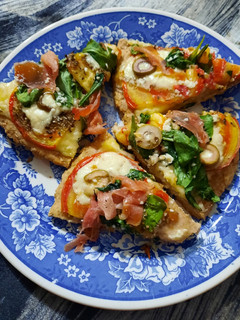 Una foto de Pizza integral, tomate, rúcula y crudo